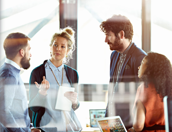 Four people standing having an interactive discussion