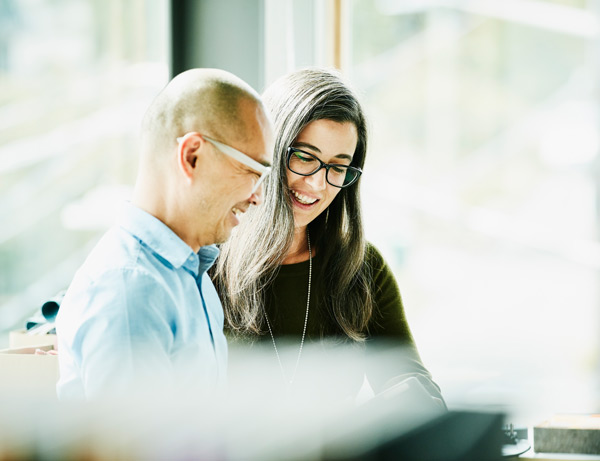 A man and woman have a discussion smiling