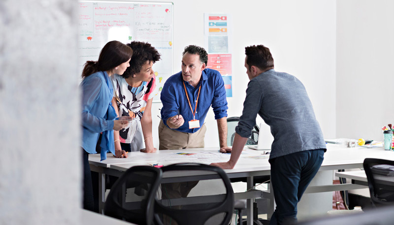 A group of people standing having an interactive discussion 