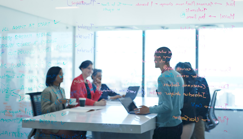 A group of people are interacting with each other informally and smiling