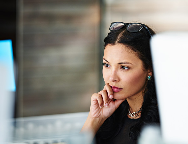 Women sits at desk looking at computer screen