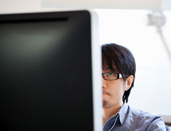 Man sits at desk looking at computer screen